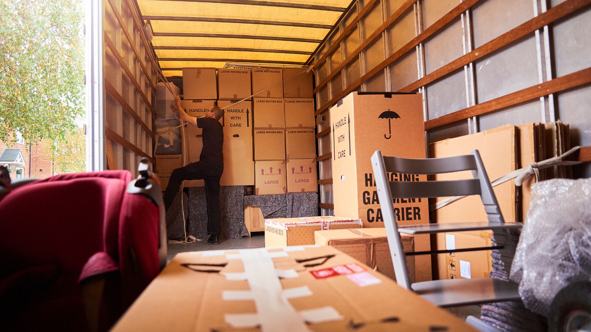 Tipos de sujeción de carga Persona implementando métodos de sujeción de carga dentro de una caja de camión para prevenir movimientos y fuerzas no deseadas